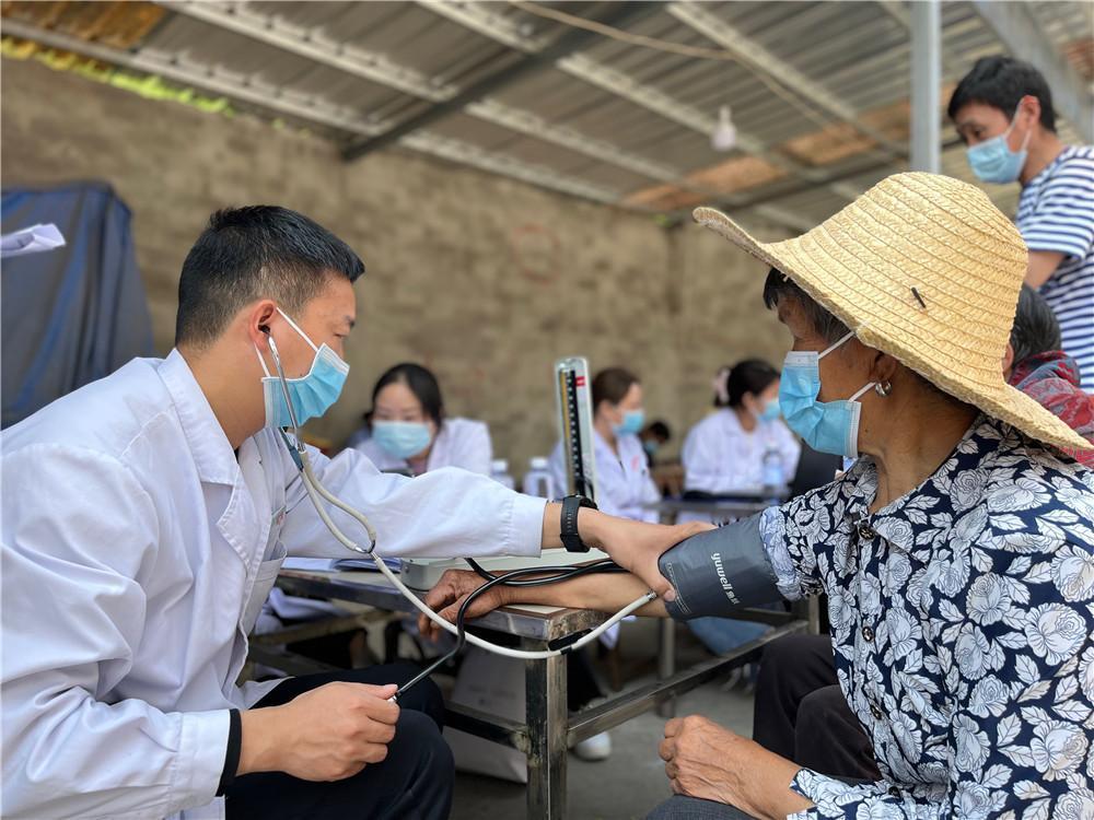 关庙镇卫生院医护志愿者上门为老人测量血压检查身体
