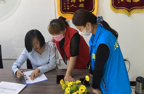 网格员和志愿者在辖区物业中心对接工作