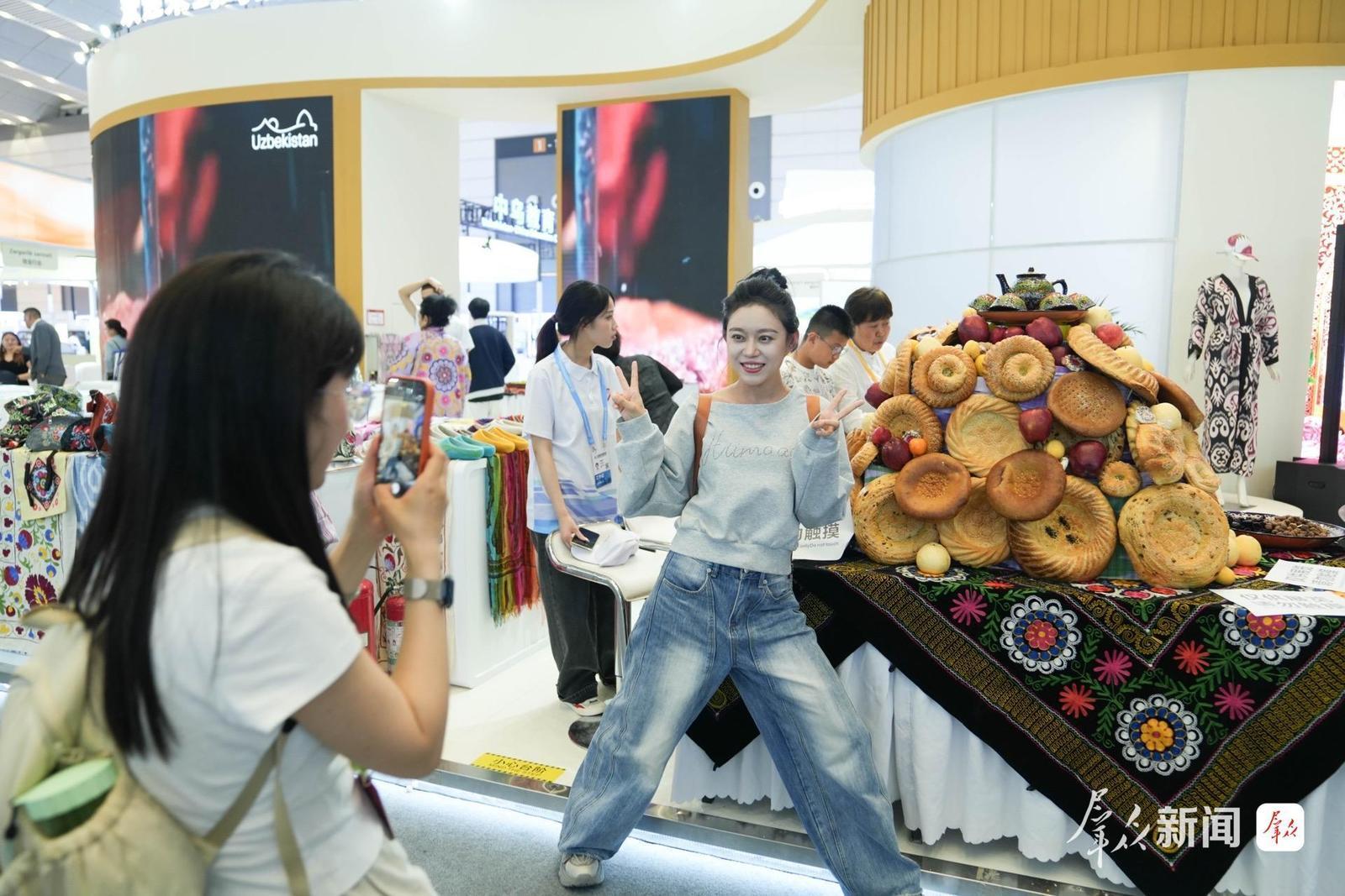 观展群众在乌兹别克斯坦展位拍照留念。